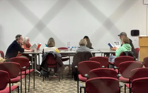 Photograph of group members reading around the conference table