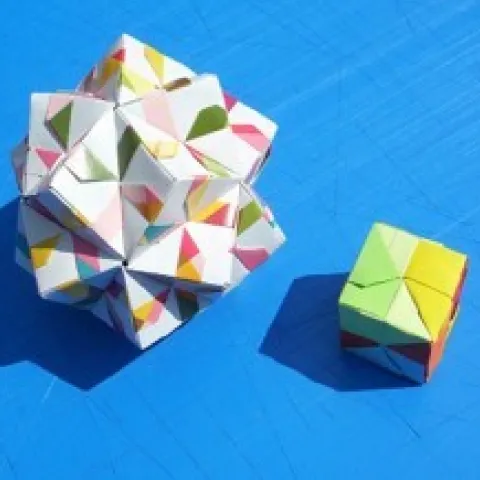 Image of a box made from folded paper and a 3D origami design on a blue background