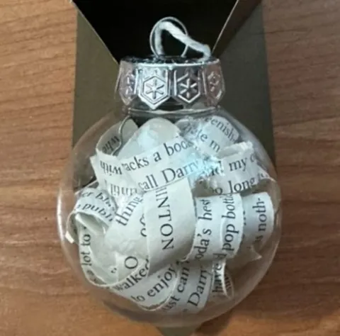 Clear Christmas tree ornament with strips of book pages filling the inside