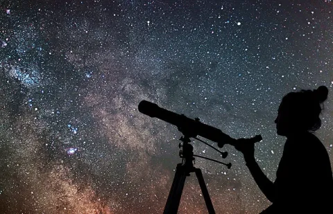telescope with person and night sky