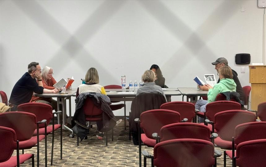 Photograph of group members reading around the conference table